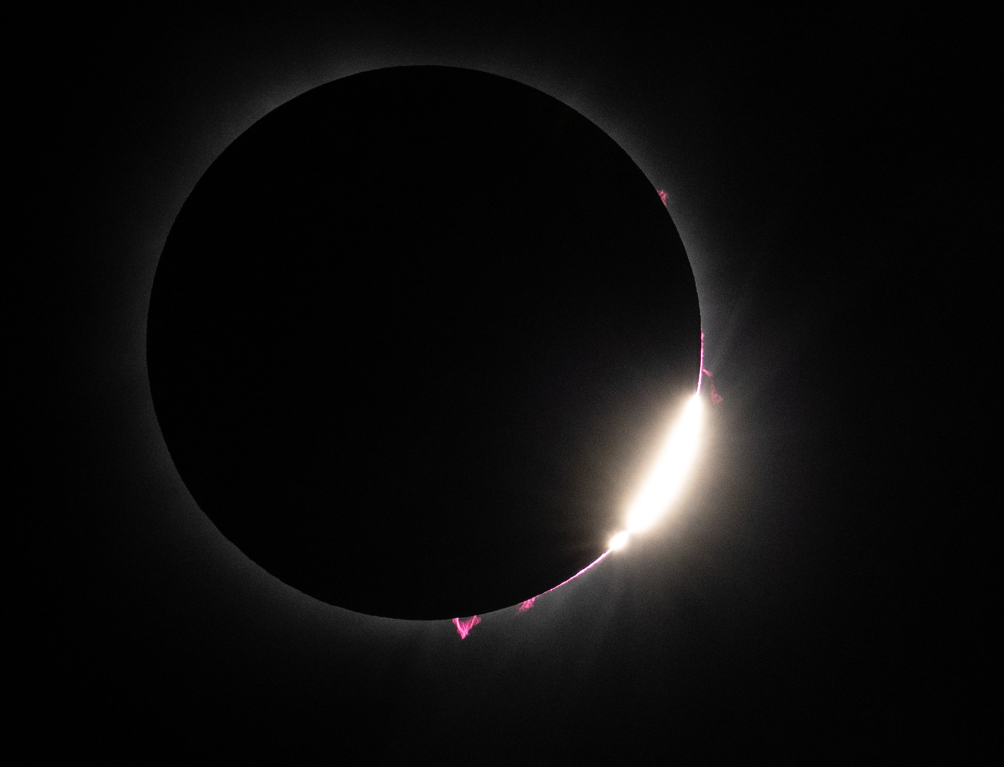 Baily's Beads and pink solar prominences visible just after totality during the April 8, 2024 solar eclipse