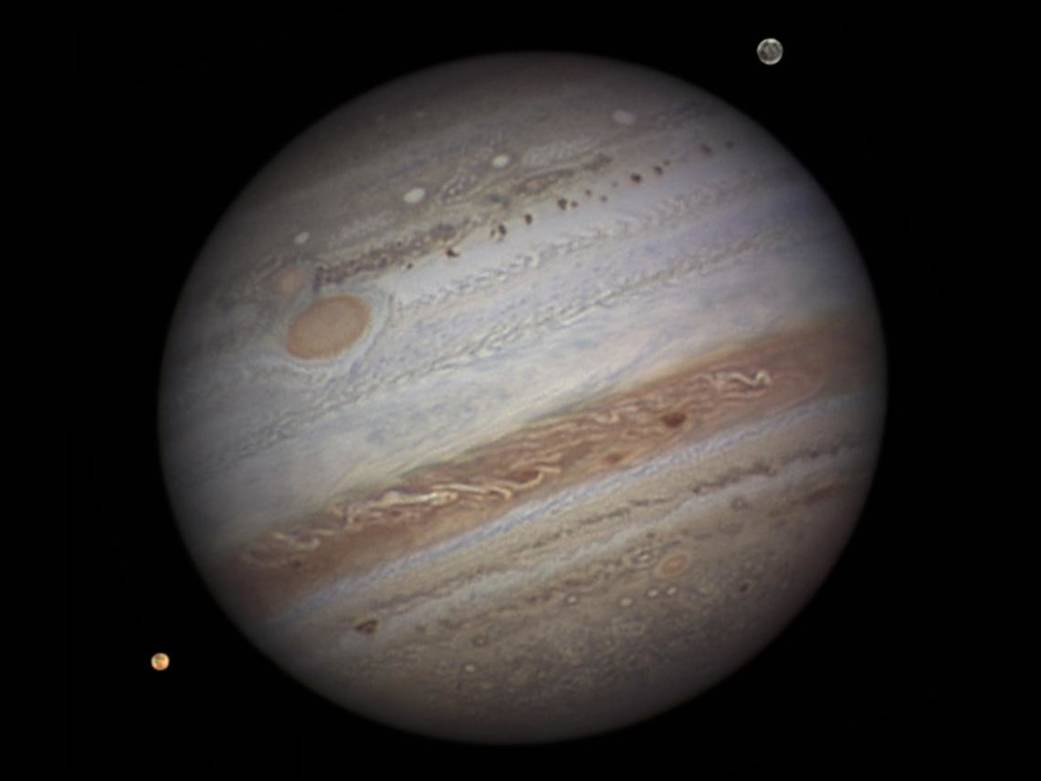 Jupiter — ground-based reference image by Damian Peach showing cloud belts, Great Red Spot, and moons Io and Ganymede
